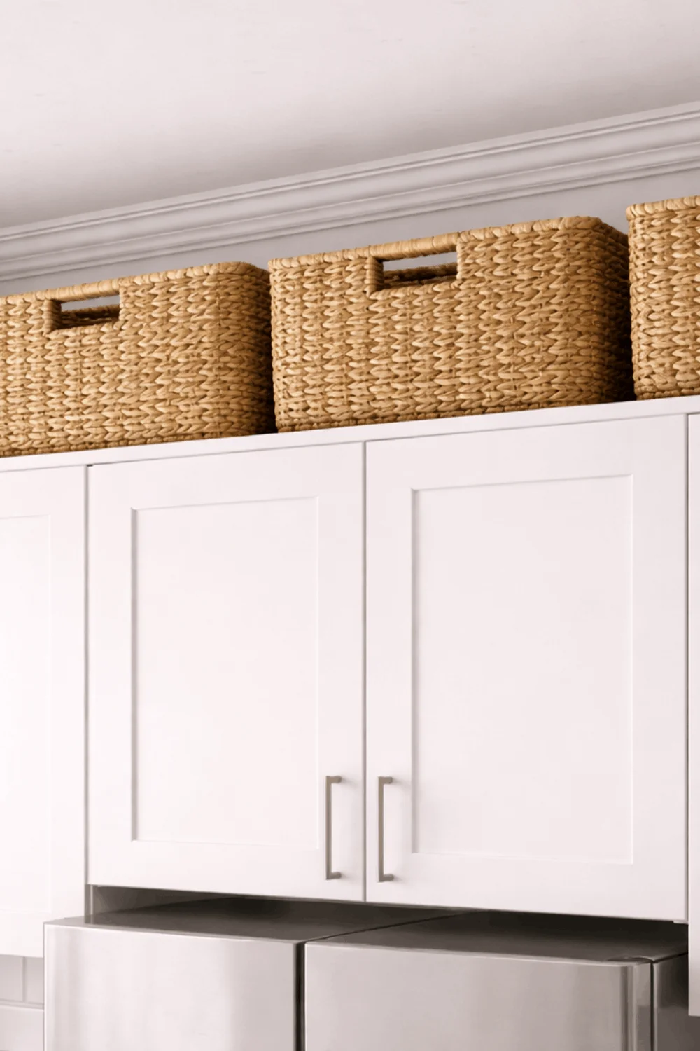 Woven wicker baskets neatly arranged on top of kitchen cabinets, utilizing vertical space for hidden storage in a tiny kitchen.
